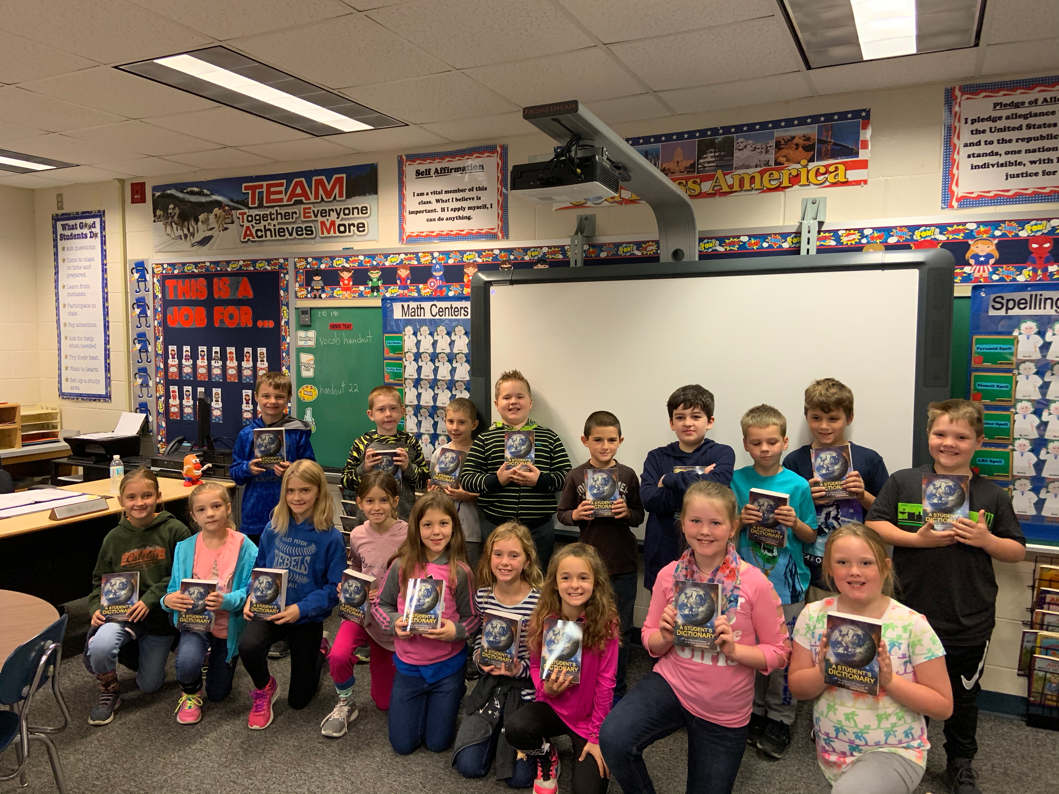 Third graders pose proudly with their new dictionaries.